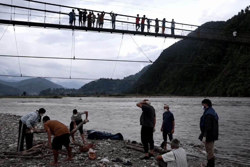 Cứu hộ lũ Nepal đi cùng nỗi đau hậu thảm họa, khi người thân chuẩn bị hỏa táng nạn nhân bên sông Suryamati ở Nuwakot.