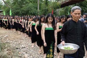 Gần 100 thiếu nữ người Thái thực hiện nghi thức gội đầu bên suối Nậm Pe tại lễ hội Ngày hội mùa vàng ở Lai Châu.